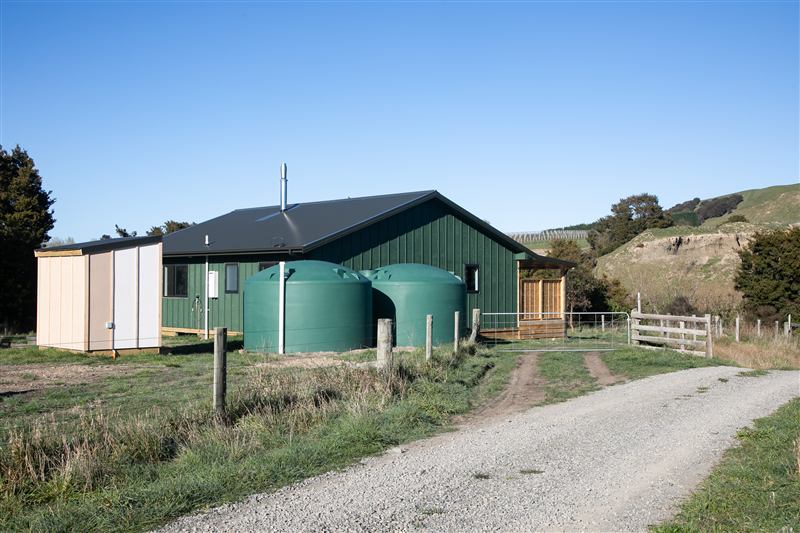 Green farm cabin with water tanks