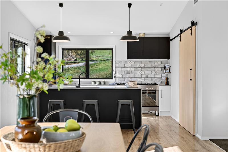 Modern kitchen with a black island and sliding barn door
